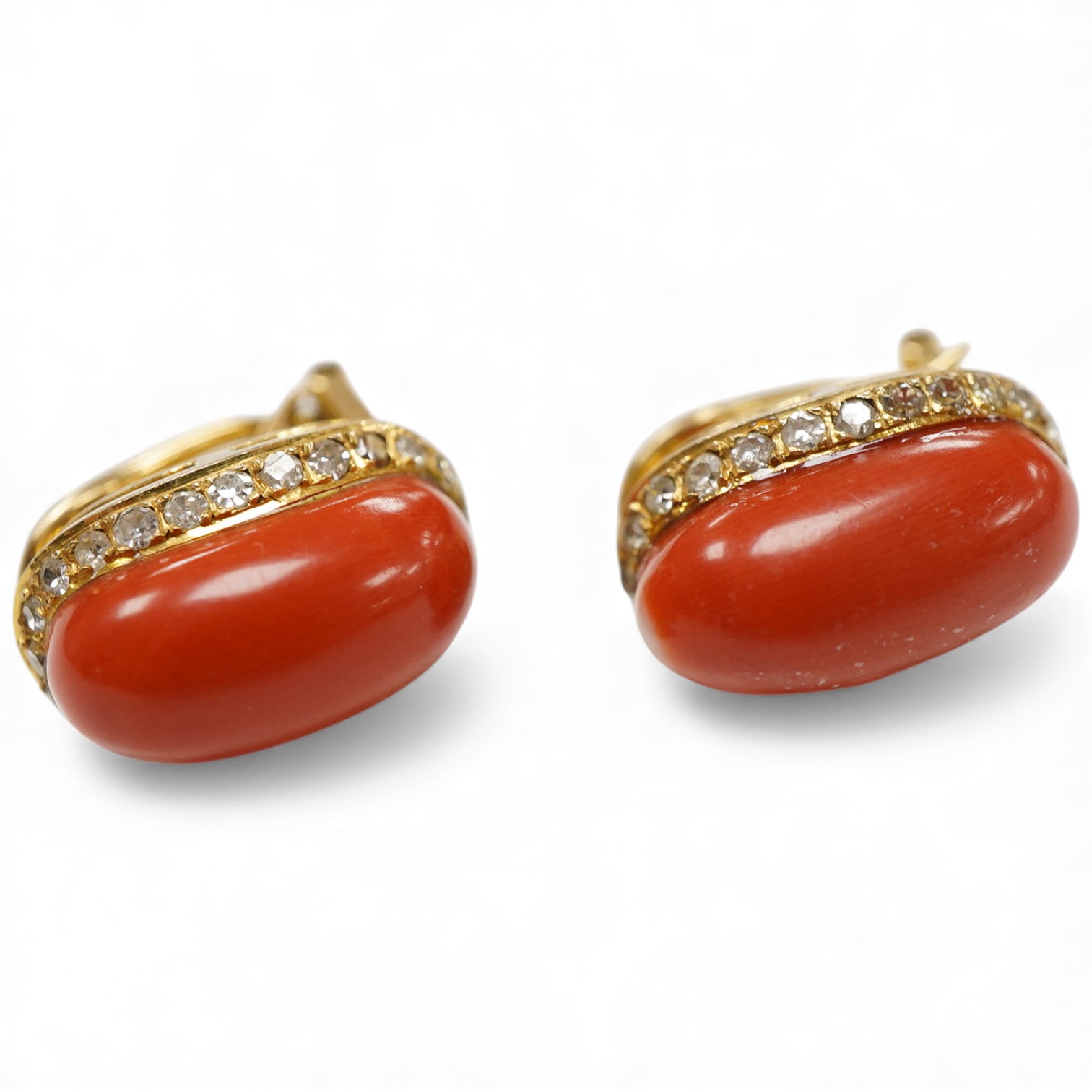 A pair of recent yellow metal, coral and diamond ear ring/clips, each oval coral bordered with diamonds, 15mm.